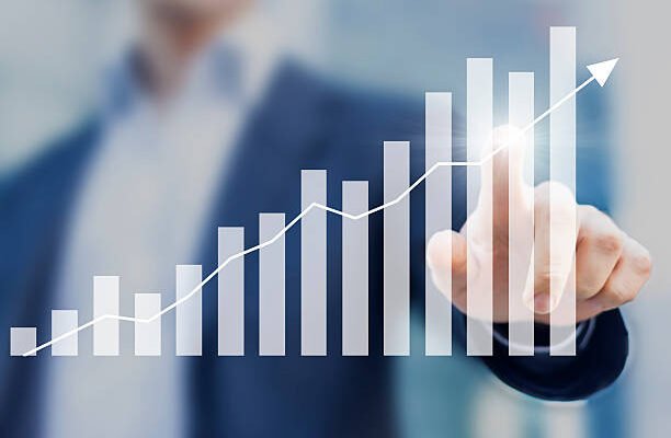 Business success with growing, rising charts and businessman in background